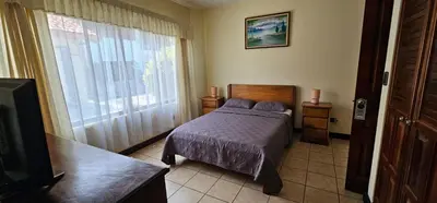 a bedroom with a bed and a large window at Apartotel Obelisco San José Aeropuerto in San José