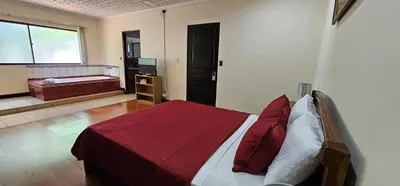 a bedroom with a bed with a red blanket at Apartotel Obelisco San José Aeropuerto in San José