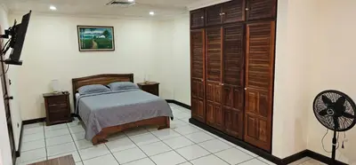a bedroom with a bed and a large closet at Apartotel Obelisco San José Aeropuerto in San José