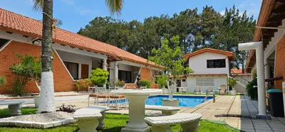 a house with a swimming pool in a yard at Apartotel Obelisco San José Aeropuerto in San José