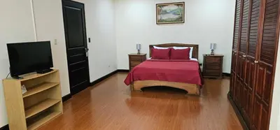 a bedroom with a bed and a flat screen tv at Apartotel Obelisco San José Aeropuerto in San José