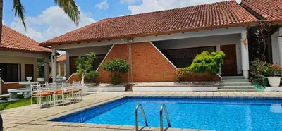a house with a swimming pool in front of a house at Apartotel Obelisco San José Aeropuerto in San José