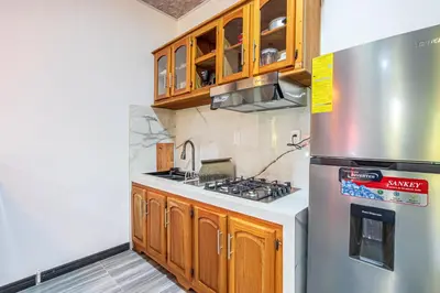 a kitchen with wooden cabinets and a stainless steel refrigerator at Apartamentos Luna in Uvita