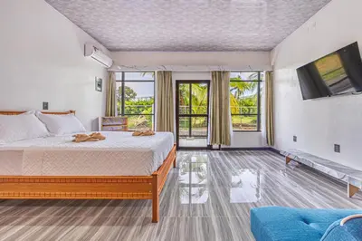 a bedroom with a bed and a tv and a couch at Apartamentos Luna in Uvita