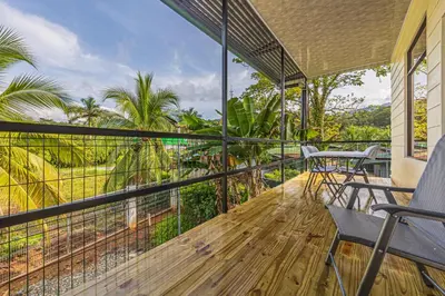 a balcony with chairs and a view of the jungle at Apartamentos Luna in Uvita