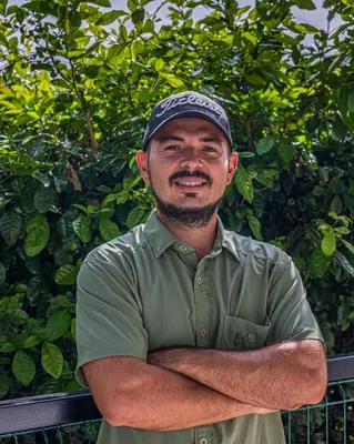 a man wearing a hat with his arms crossed at Apartamentos Luna in Uvita