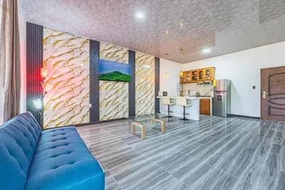 a living room with a blue couch and a kitchen at Apartamentos Luna in Uvita