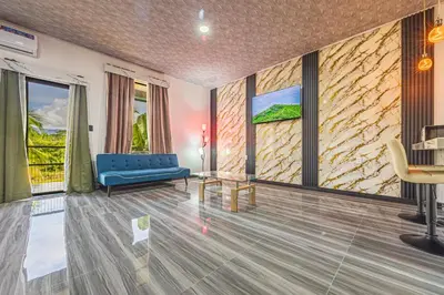 a living room with a blue couch and windows at Apartamentos Luna in Uvita