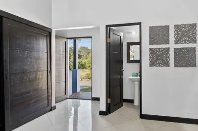 a bathroom with two wooden doors and a sink at Casa Dasani - Beautiful House with private pool in Santa Rosa