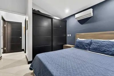 a bedroom with a large bed and a blue wall at Casa Dasani - Beautiful House with private pool in Santa Rosa
