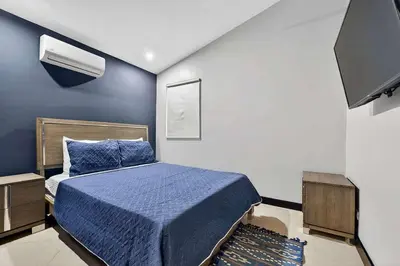 a bedroom with a blue bed and a tv at Casa Dasani - Beautiful House with private pool in Santa Rosa