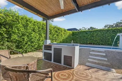 a patio with a table and chairs and a counter at Casa Dasani - Beautiful House with private pool in Santa Rosa