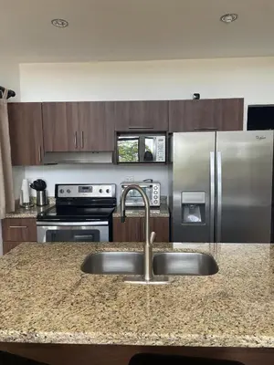 a kitchen with a sink and a stainless steel refrigerator at Jungle Paradise in Santa Cruz