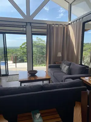 a living room with two couches and a large window at Jungle Paradise in Santa Cruz
