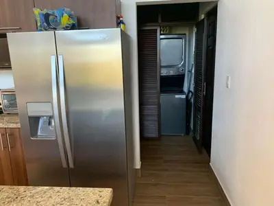 a stainless steel refrigerator in a kitchen with a hallway at Jungle Paradise in Santa Cruz