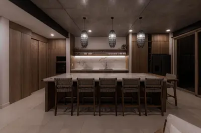 a kitchen with a large island with bar chairs at The Town at Praia in Jacó