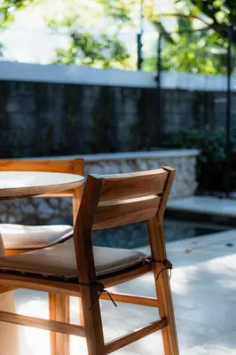 a wooden chair sitting in front of a table at The Town at Praia in Jacó