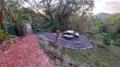 a garden with a table and a bench in the grass at Casa Monstera Monteverde in Cebadilla