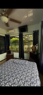 a bedroom with a bed and a large window at Tres Diamantes Casa Completa in Parrita