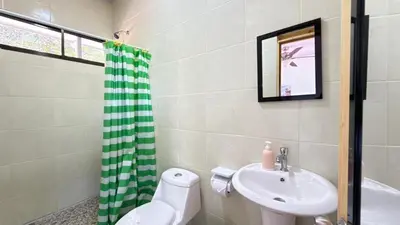 a bathroom with a sink and a toilet and a shower at Tres Diamantes Habitaciones con piscina in Parrita