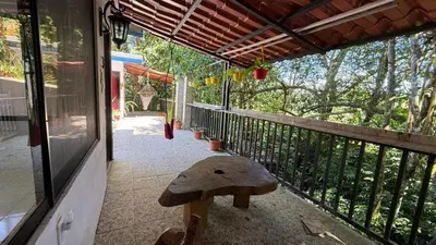 a bench sitting on the balcony of a house at Tres Diamantes Habitaciones con piscina in Parrita