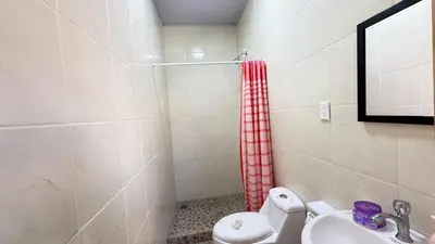 a bathroom with a toilet and a sink at Tres Diamantes Habitaciones con piscina in Parrita