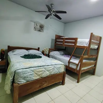 a bedroom with two beds and a ceiling fan at Tres Diamantes Habitaciones con piscina in Parrita
