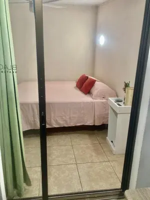 a small bedroom with a small bed with pink sheets at Flamingo 107 Cabins apartment, 100mts from the beach in Playa Flamingo