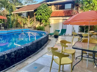 a patio with tables and chairs next to a swimming pool at Flamingo 107 Cabins apartment, 100mts from the beach in Playa Flamingo