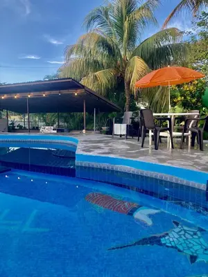 a swimming pool with a table and an umbrella at Flamingo 107 Cabins apartment, 100mts from the beach in Playa Flamingo