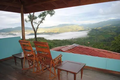 two chairs and a table on a balcony with a view at Toucan Villa in Caña Blanca