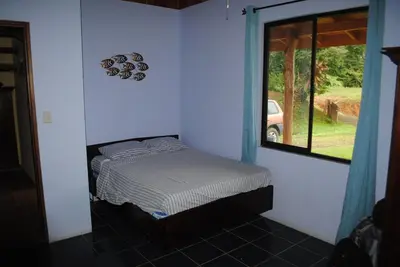 a small bed in a room with a window at Toucan Villa in Caña Blanca