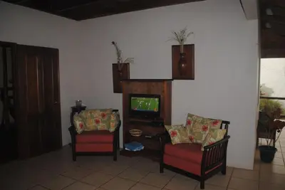 a living room with two chairs and a television at Toucan Villa in Caña Blanca