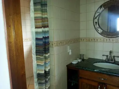 a bathroom with a sink and a mirror at Toucan Villa in Caña Blanca