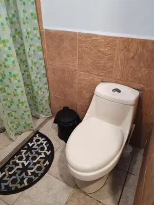 a white toilet in a bathroom with a shower curtain at Bonito apartamento 103 frente a la piscina 100mt del mar in Playa Flamingo