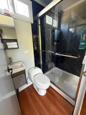 a bathroom with a toilet and a shower and a sink at Cabaña BosKaL in Quesada