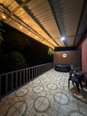 a patio with a table and chairs and a hot tub at Cabaña BosKaL in Quesada