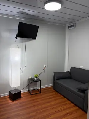 a living room with a couch and a flat screen tv at Cabaña BosKaL in Quesada
