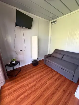 a living room with a couch and a flat screen tv at Cabaña BosKaL in Quesada