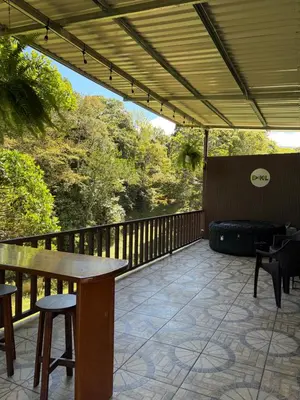 a patio with a table and chairs on a deck at Cabaña BosKaL in Quesada
