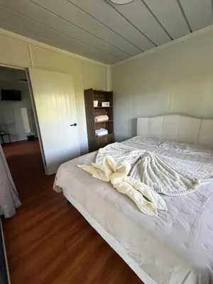 a bedroom with a white bed with towels on it at Cabaña BosKaL in Quesada