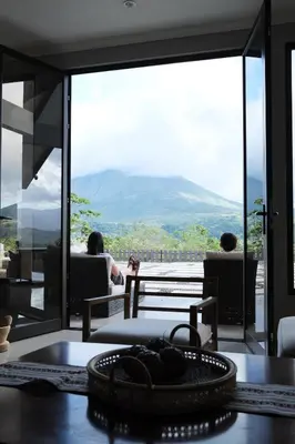 two people sitting at a table with a view of a mountain at Arenal, Completely Yours Ultra Private Estate in Fortuna