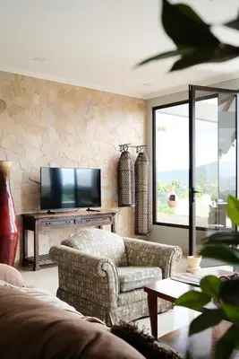 a living room with a couch and a flat screen tv at Arenal, Completely Yours Ultra Private Estate in Fortuna