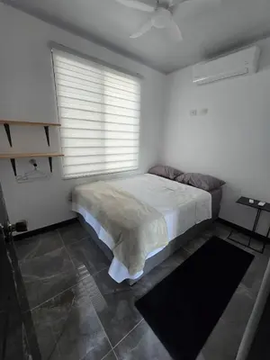 a white bedroom with a bed and a window at Casa Motmot en Liberia in Liberia