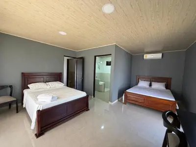 a bedroom with two beds and a chair in it at Hacienda Santa Elena in Santa Cruz