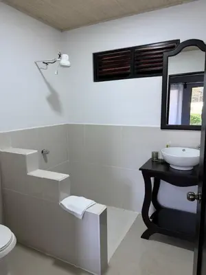 a white bathroom with a sink and a mirror at Hacienda Santa Elena in Santa Cruz
