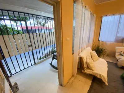 a room with a balcony with a couch and a window at Casa Todah Av 5 in Liberia