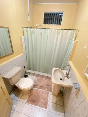 a bathroom with a toilet and a sink and a shower at Casa Todah Av 5 in Liberia