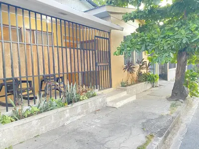 a building with a fence and a table and chairs at Casa Todah Av 5 in Liberia
