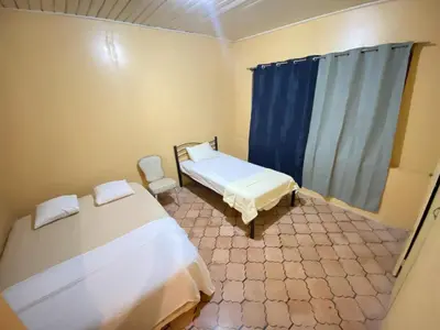 a small room with two beds and a window at Casa Todah Av 5 in Liberia